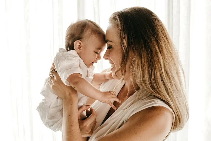 Joyful mother cradling her smiling baby